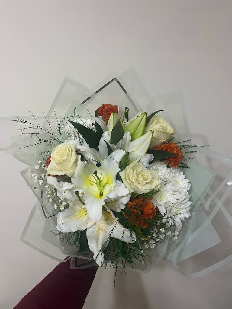Beautiful flower bouquet featuring white lilies, roses, and orange carnations with exquisite details.